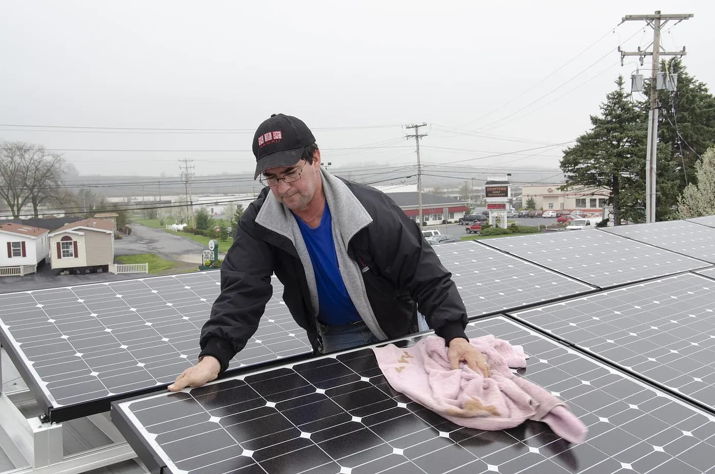 Técnico limpiando un panel solar en un techo